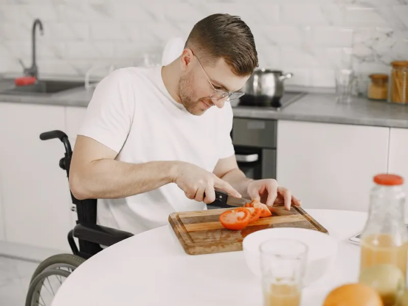 Support worker helping a participant with household chores at home