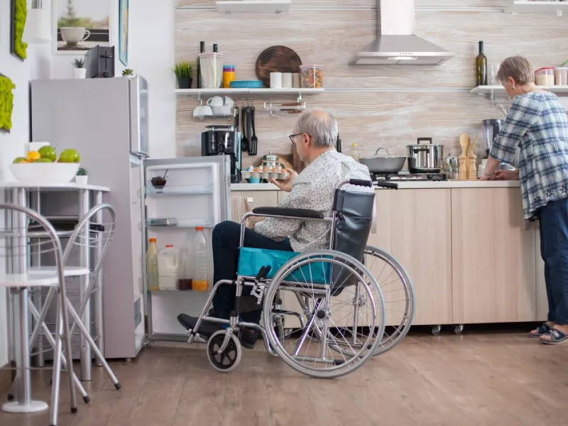 Support worker assisting a participant with folding laundry