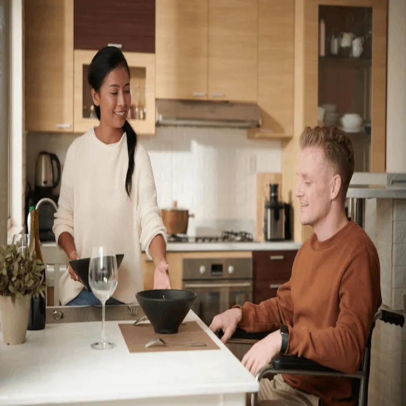 Support worker helping a participant with grocery shopping and organising the kitchen
