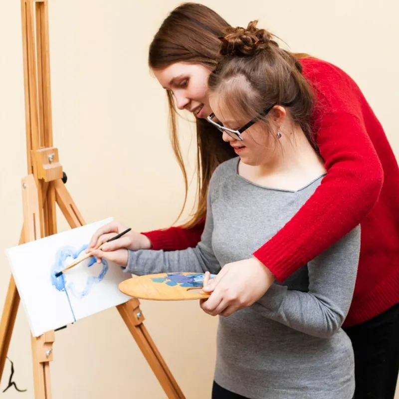 Support worker helping a participant with meal preparation as part of life skills training